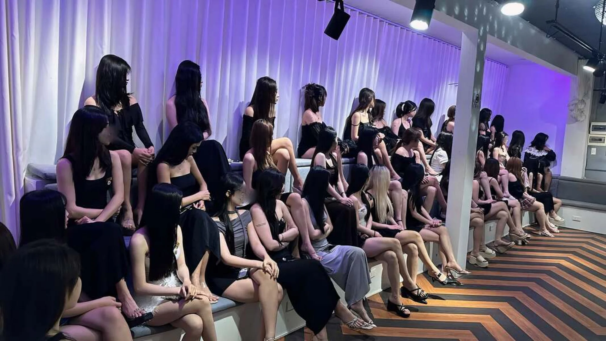 岘港Boss Bar Lounge女性工作人员坐在休闲座位上的场景。