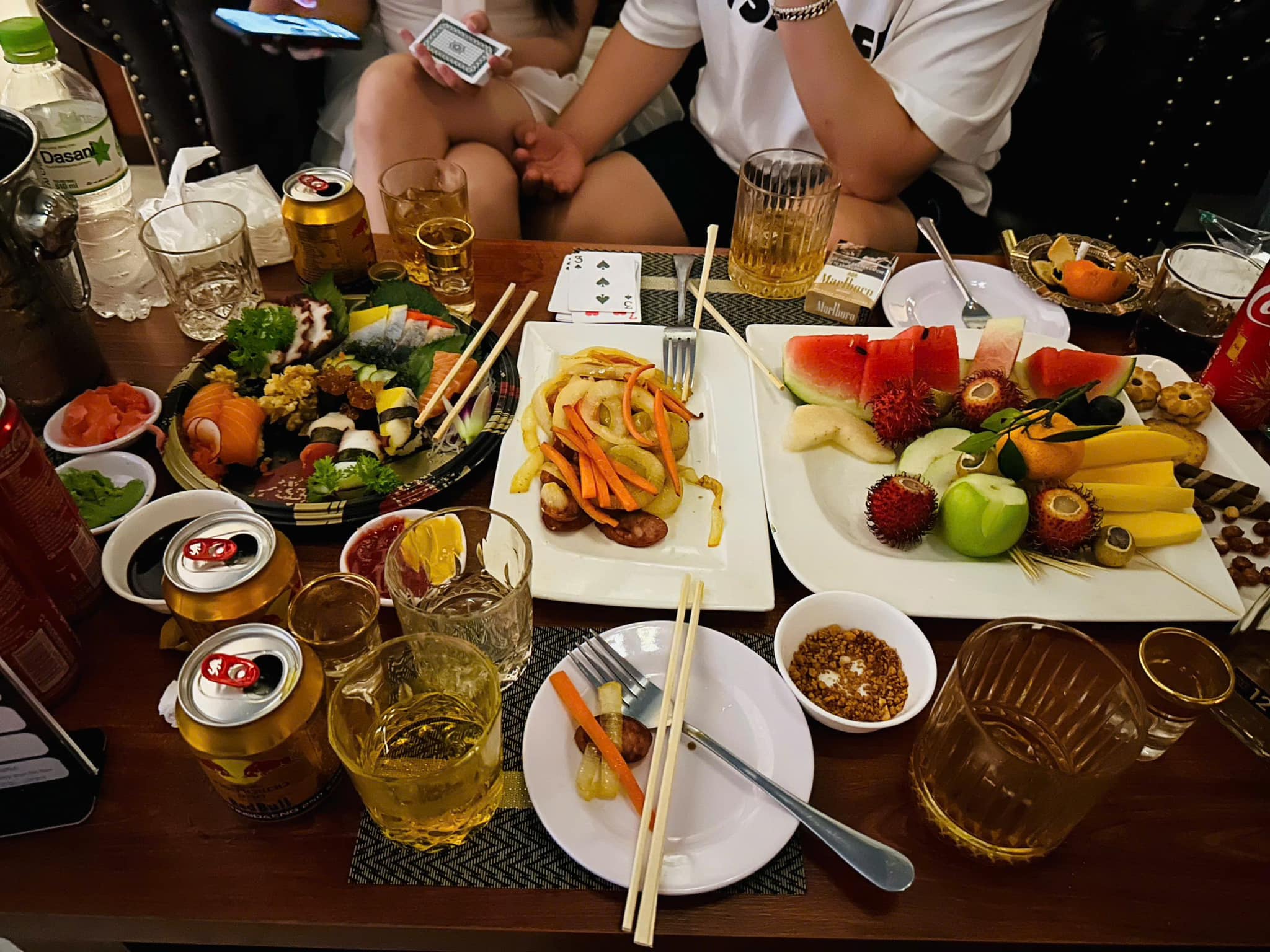 峴港Boss Bar Lounge的美食、水果拼盤、啤酒和威士忌桌面佈置。